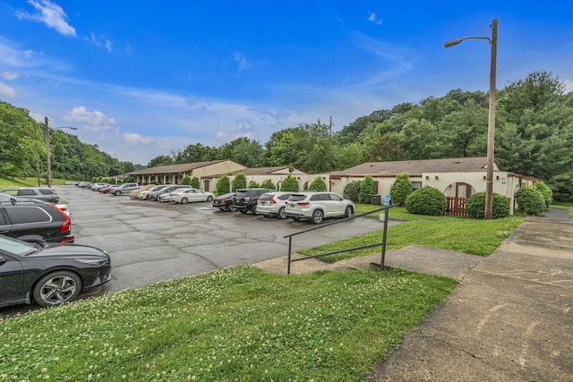 view of parking with a lawn