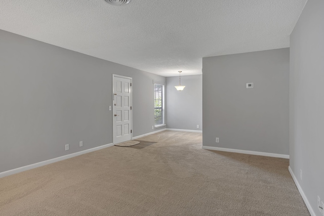 unfurnished room with light carpet and a textured ceiling