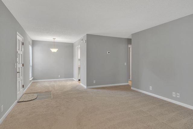 carpeted empty room featuring a textured ceiling