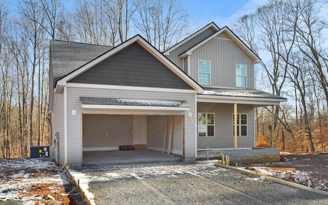 view of front of home with cooling unit, a garage, and covered porch