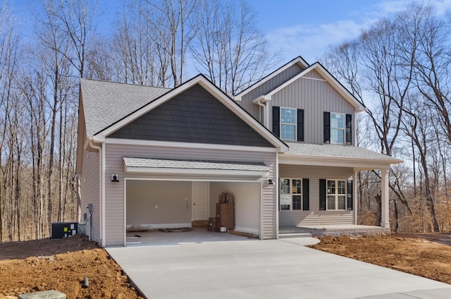 view of front of property featuring a garage, roof with shingles, covered porch, and concrete driveway