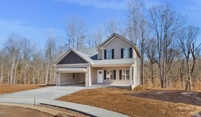 traditional-style home with covered porch, driveway, and a garage