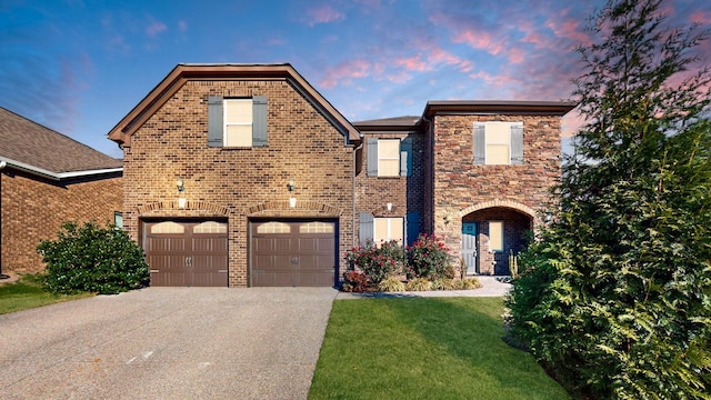 view of front of property with a garage and a lawn