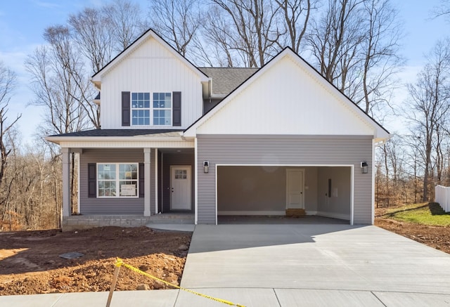 view of front of house with a garage, roof with shingles, covered porch, and concrete driveway