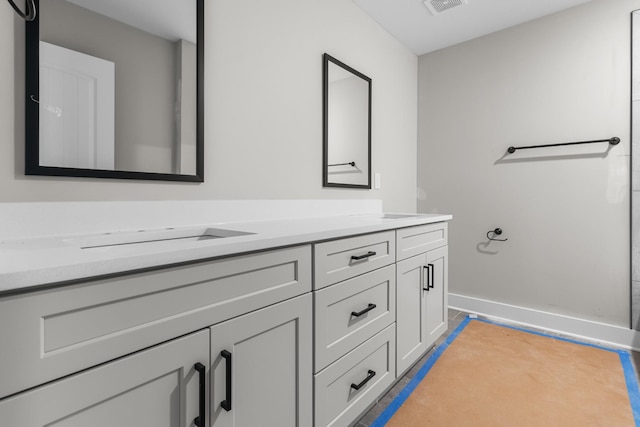 bathroom featuring vanity, visible vents, and baseboards