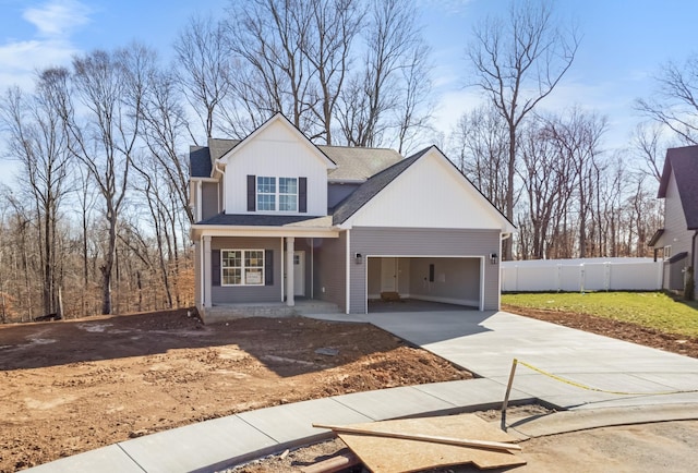 view of front of house featuring concrete driveway, fence, a garage, and a shingled roof