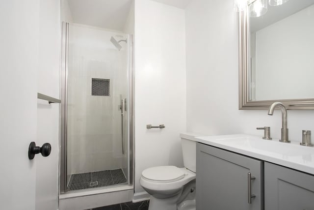 bathroom featuring vanity, toilet, and a shower with door