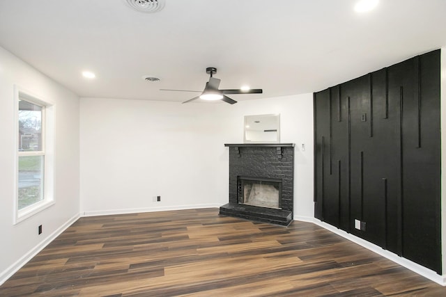 unfurnished living room featuring ceiling fan, dark hardwood / wood-style flooring, and a fireplace