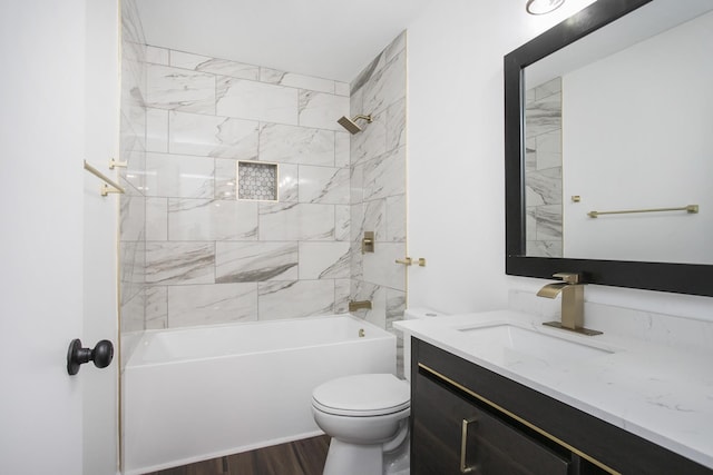 full bathroom with hardwood / wood-style floors, tiled shower / bath combo, toilet, and vanity