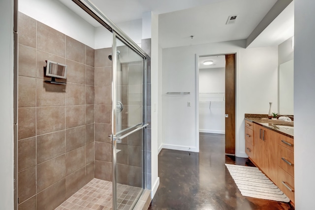 bathroom with vanity, concrete floors, and a shower with shower door