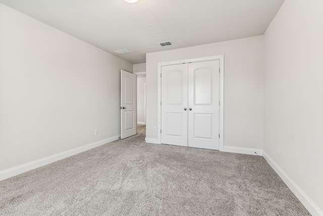 unfurnished bedroom with a closet and carpet floors