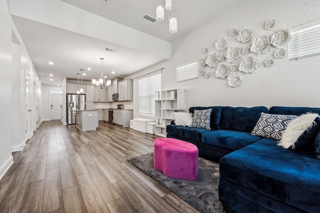 living room featuring an inviting chandelier and light hardwood / wood-style flooring