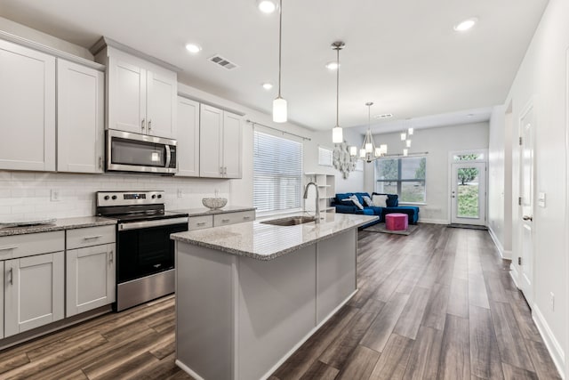 kitchen with dark hardwood / wood-style flooring, a wealth of natural light, sink, and appliances with stainless steel finishes