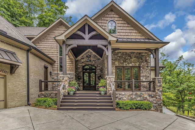 view of exterior entry featuring french doors and covered porch