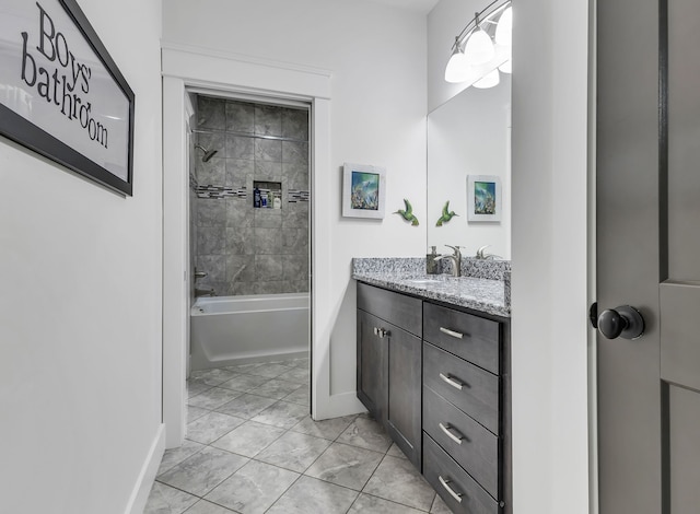 bathroom with tile patterned flooring, vanity, and tiled shower / bath combo