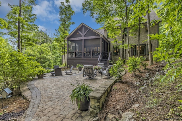 view of patio / terrace with a sunroom and an outdoor fire pit