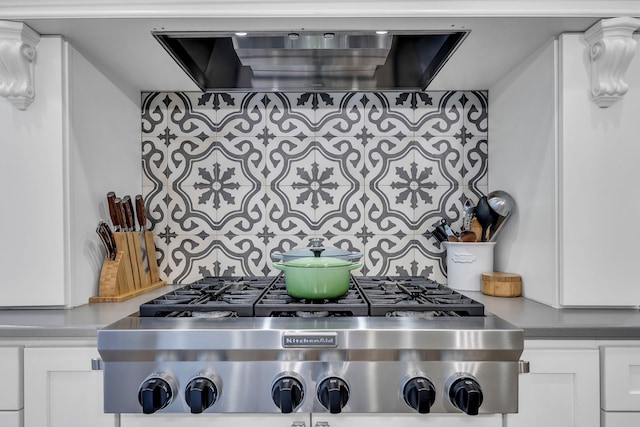 kitchen with white cabinets, stainless steel gas stovetop, and extractor fan