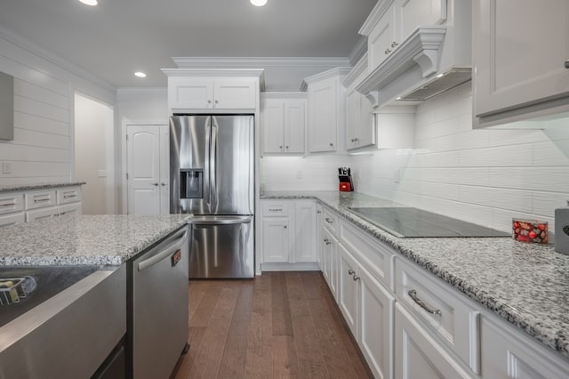 kitchen with light stone countertops, custom exhaust hood, stainless steel appliances, white cabinets, and dark hardwood / wood-style floors