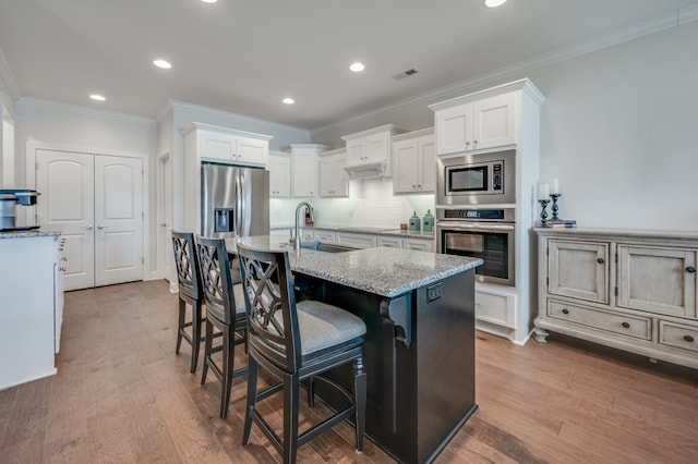 kitchen with light wood-type flooring, white cabinetry, sink, and appliances with stainless steel finishes