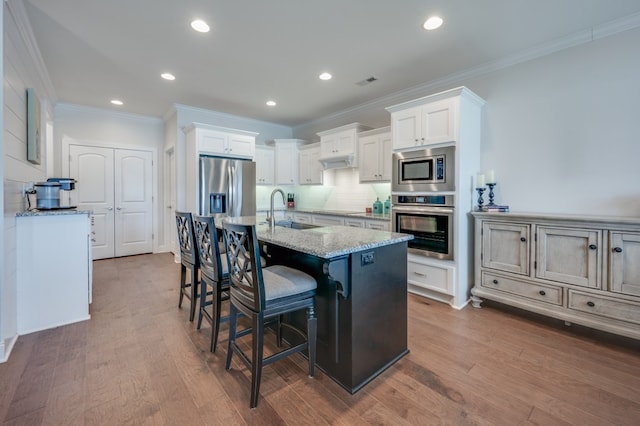 kitchen featuring white cabinets, sink, dark hardwood / wood-style floors, light stone countertops, and stainless steel appliances