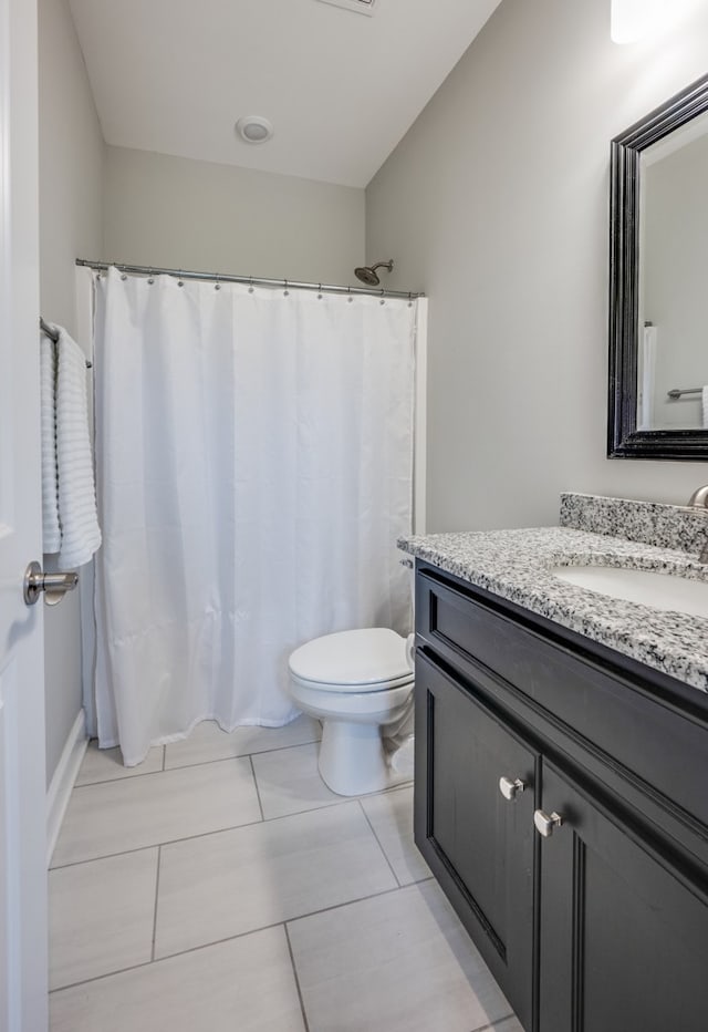 bathroom featuring tile patterned floors, vanity, and toilet