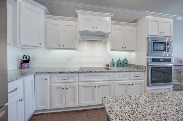 kitchen with crown molding, white cabinets, ventilation hood, and appliances with stainless steel finishes