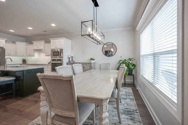 dining space featuring a wealth of natural light, sink, dark hardwood / wood-style floors, and ornamental molding