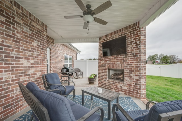 view of patio with an outdoor living space with a fireplace and ceiling fan