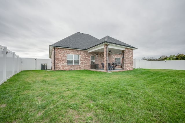 rear view of house featuring a lawn, central AC, ceiling fan, and a patio