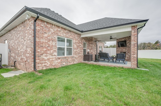 back of property featuring central air condition unit, ceiling fan, a yard, a fireplace, and a patio area