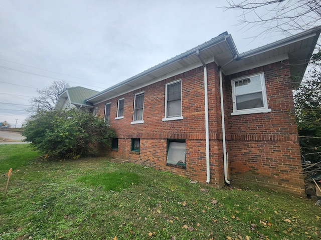 view of side of home with a lawn