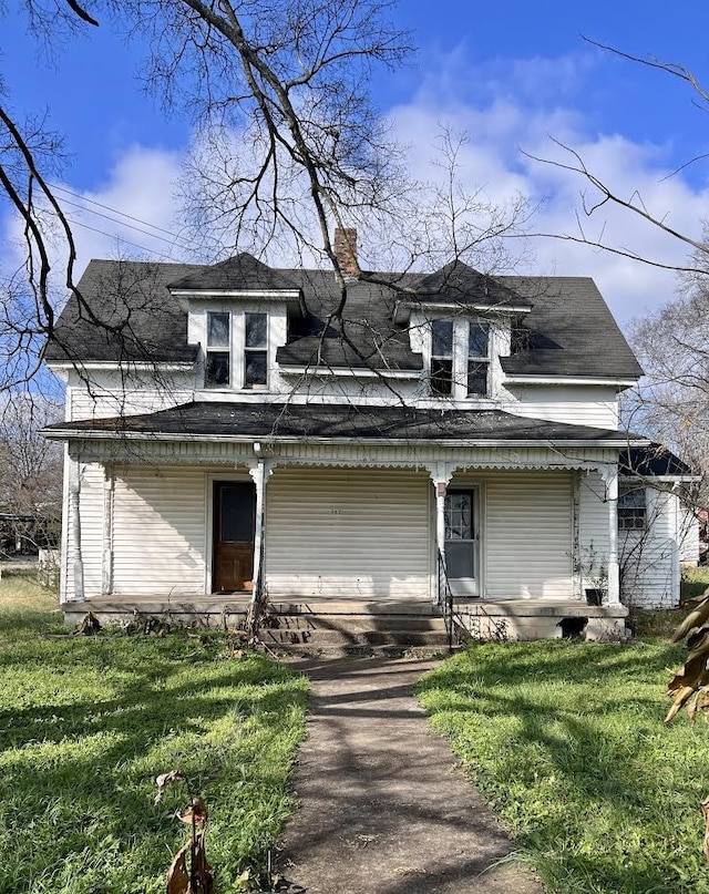 view of front of home with a porch and a front yard