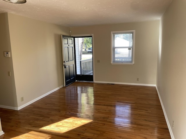 entrance foyer with a textured ceiling and dark hardwood / wood-style floors