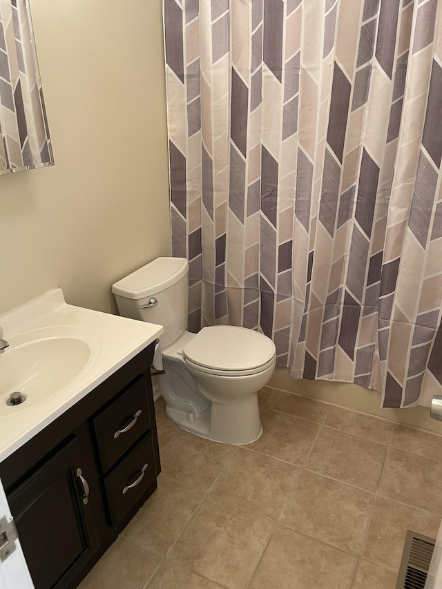 bathroom with tile patterned flooring, vanity, and toilet