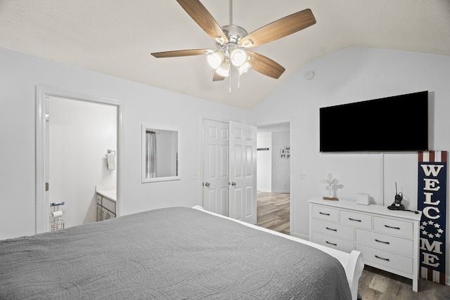 bedroom with connected bathroom, ceiling fan, dark hardwood / wood-style flooring, and vaulted ceiling