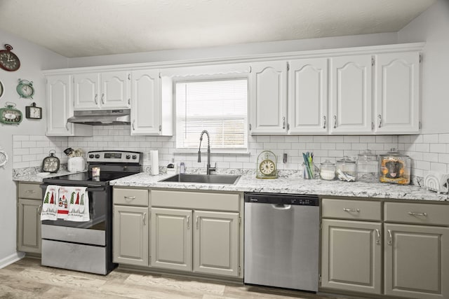 kitchen with light wood-type flooring, white cabinetry, sink, and appliances with stainless steel finishes