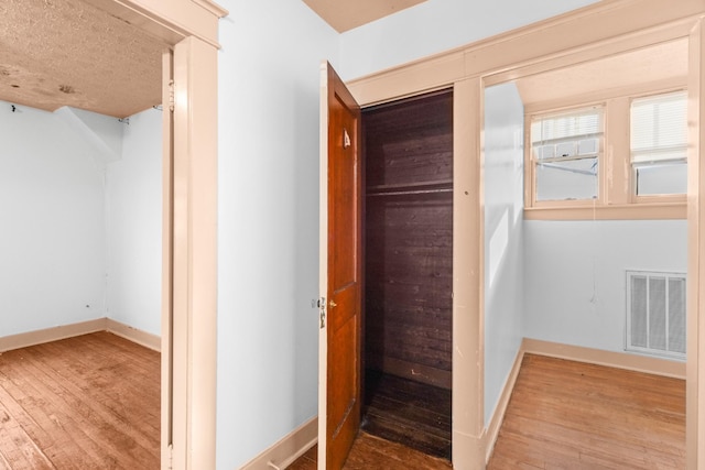 hallway with hardwood / wood-style flooring