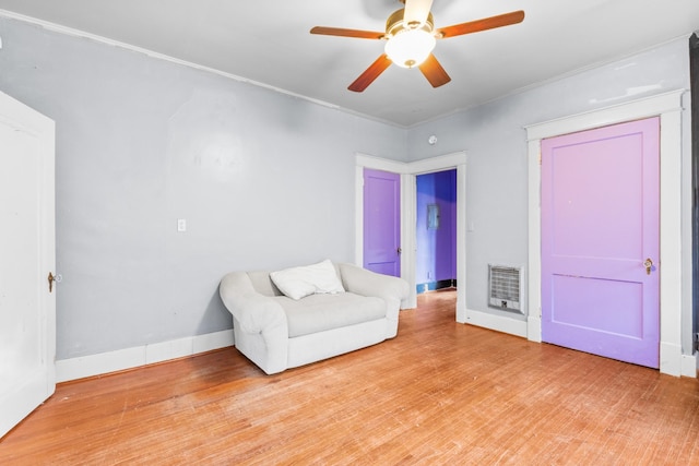 unfurnished room featuring ceiling fan, light wood-type flooring, crown molding, and heating unit