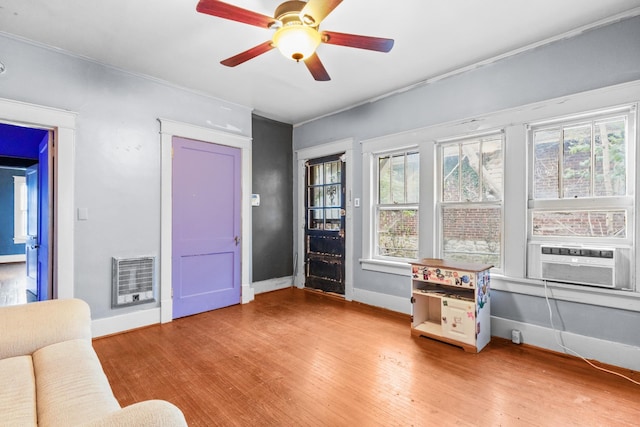 interior space featuring hardwood / wood-style floors, ceiling fan, a healthy amount of sunlight, and heating unit