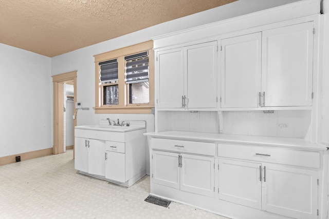 interior space with a textured ceiling and sink