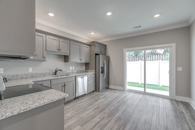 kitchen featuring gray cabinets, light stone countertops, light wood-type flooring, and stainless steel appliances