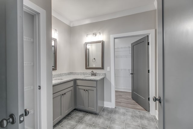 bathroom with crown molding, tile patterned flooring, and vanity