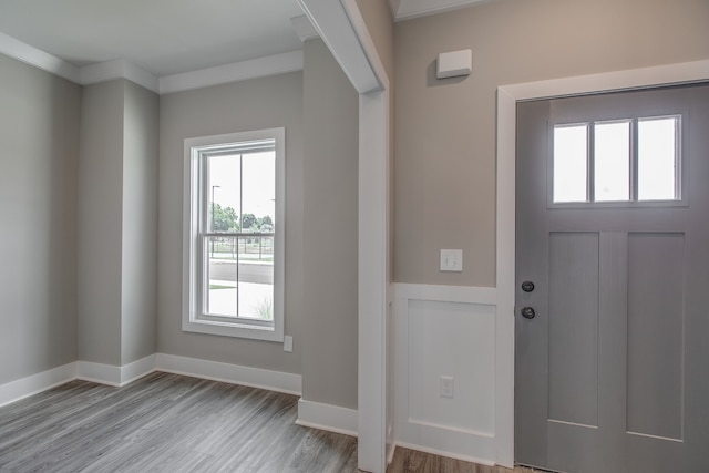 foyer featuring light wood-type flooring and crown molding