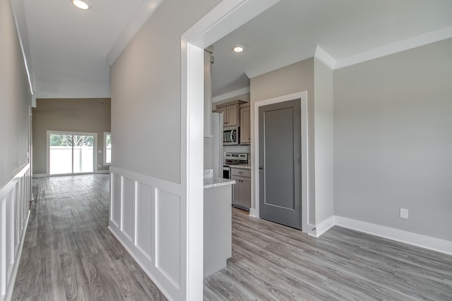 hallway featuring light hardwood / wood-style floors and ornamental molding