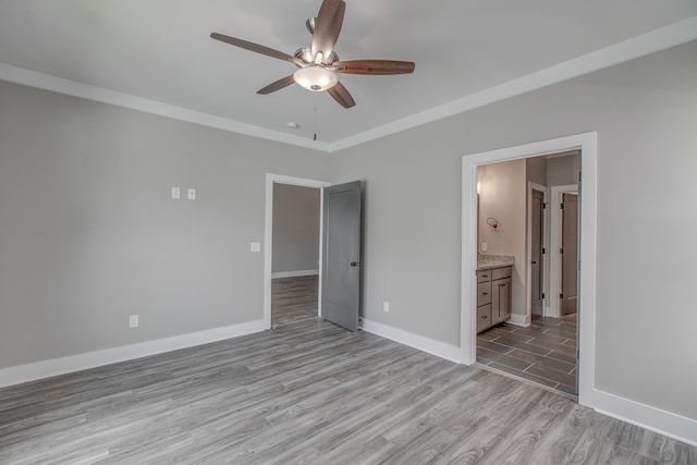 unfurnished bedroom featuring ensuite bathroom, light hardwood / wood-style floors, and ceiling fan