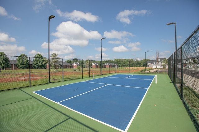 view of tennis court featuring basketball hoop