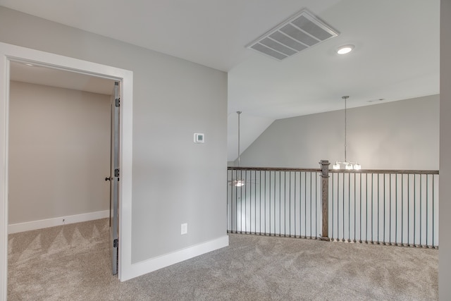 corridor featuring lofted ceiling, light carpet, and an inviting chandelier