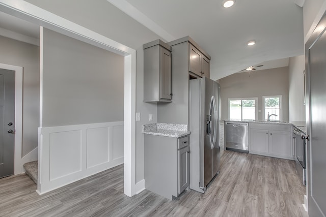 kitchen with sink, light hardwood / wood-style flooring, gray cabinets, light stone countertops, and appliances with stainless steel finishes