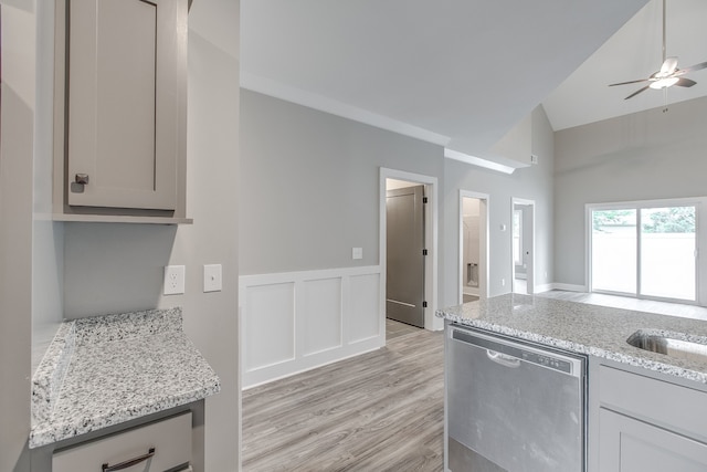 kitchen with stainless steel dishwasher, gray cabinetry, light wood-type flooring, and light stone counters