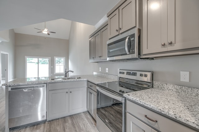 kitchen with sink, light hardwood / wood-style flooring, vaulted ceiling, ceiling fan, and stainless steel appliances